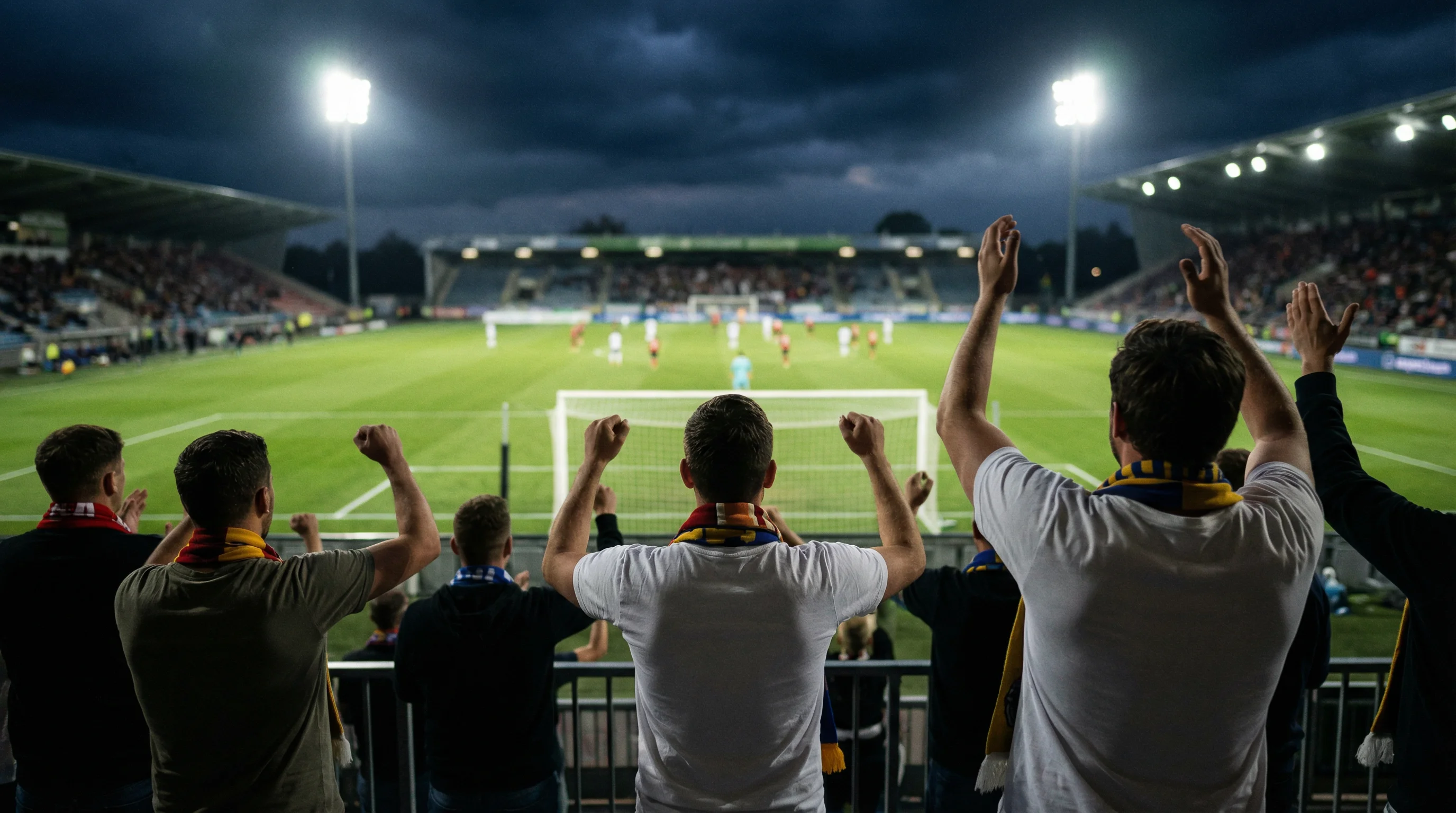 Tifosi che guardano una partita di calcio in diretta su uno schermo in uno stadio